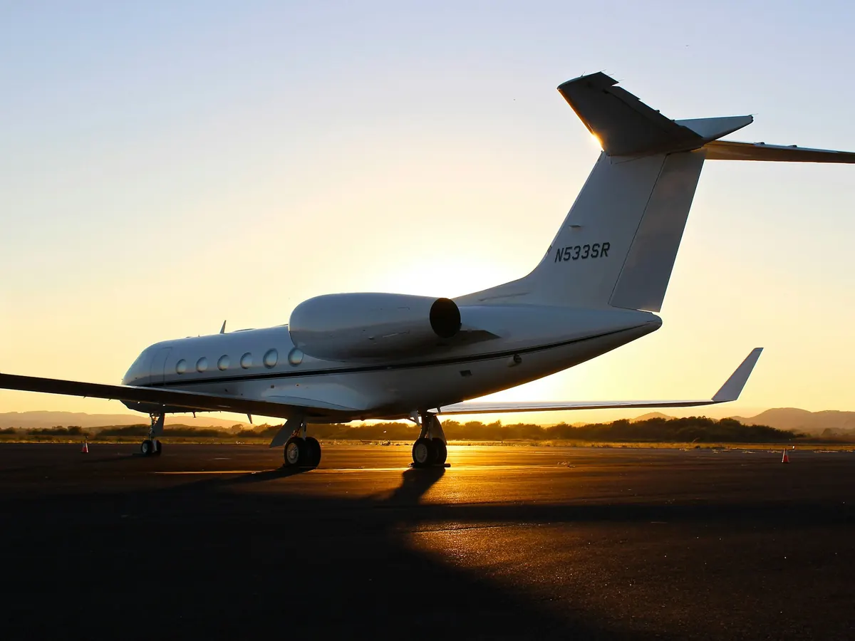 A large Gulfstream silhouetted on the ramp at sunset
