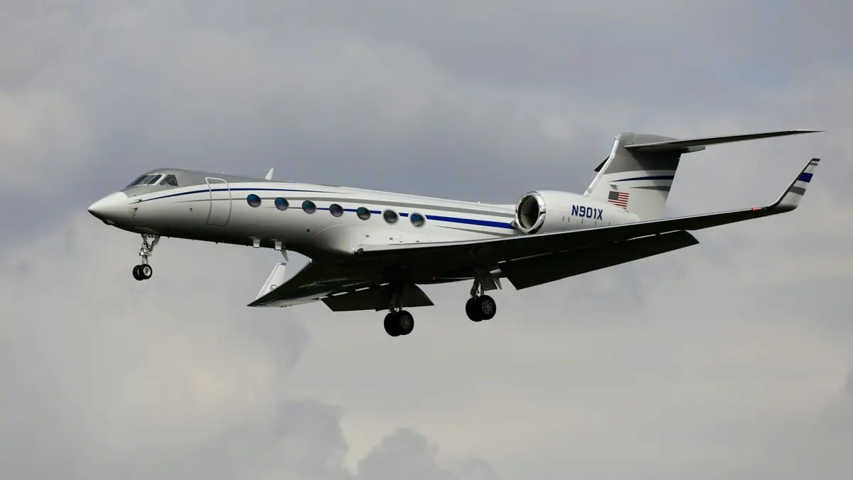A long-range Gulfstream in flight against gray cloud
