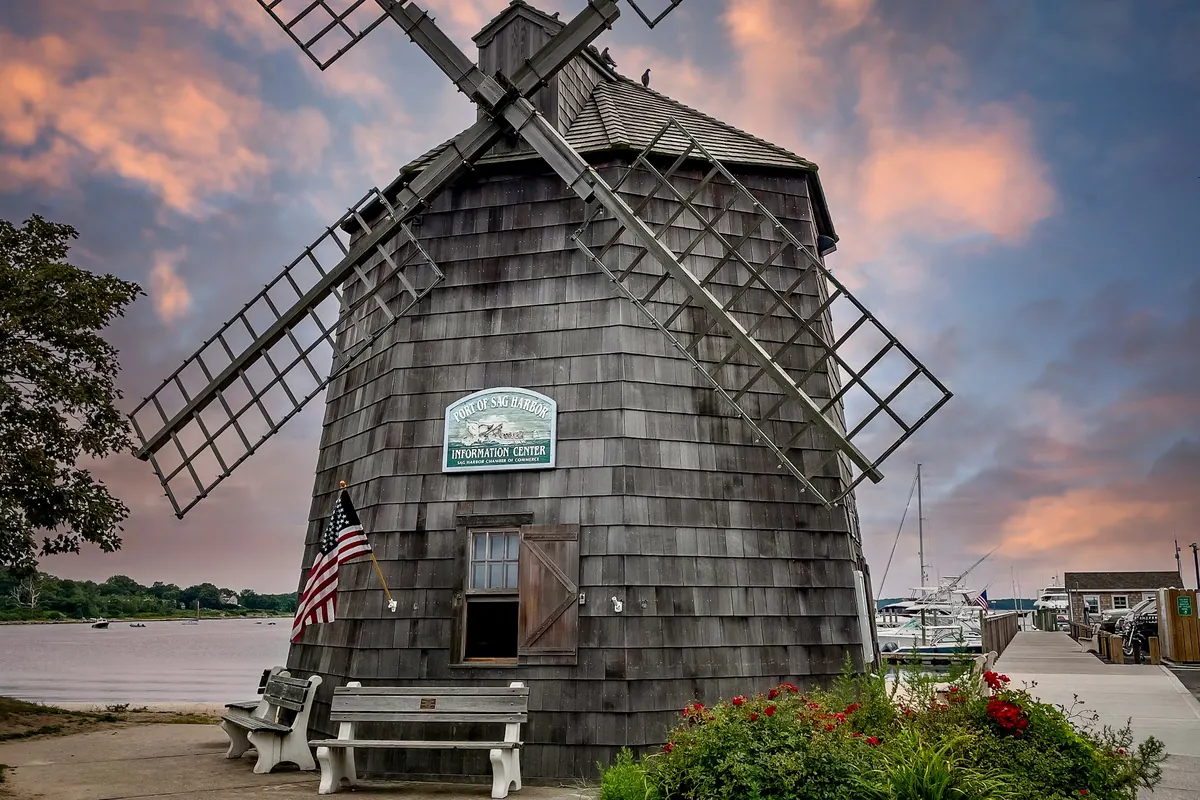A shingled windmill in the Hamptons at sunset